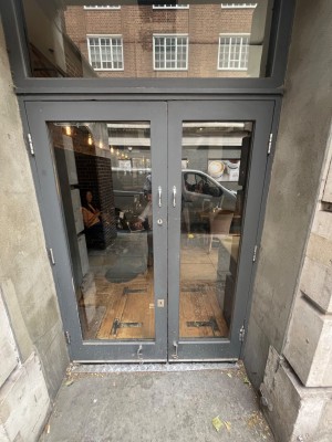 Grey framed glass doors. Pull open via handles in centre.