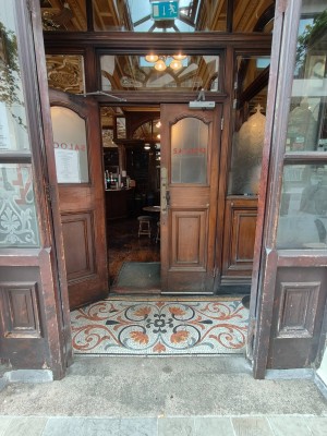 Glass and wood panelled doors. Push from centre to open.