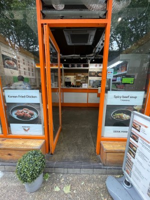 Single glass door with orange frame. Push vertical handle on right to open.