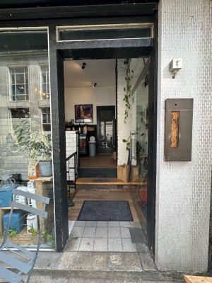 Glass door with black doorframe. Silver vertical handle to left of door. Push to open.