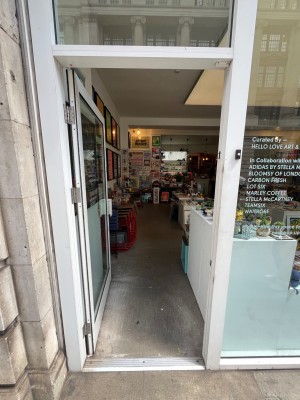 White framed glass door. Push open via handle on right.