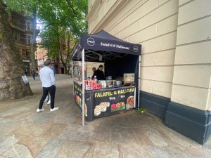 From street, facing venue. Food stand in front along wall.