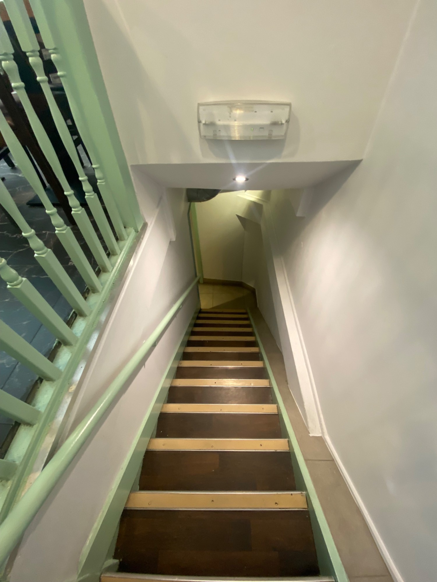 From grab rail, facing left at first flight of stairs straight ahead. Handrail along left of stairs.