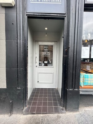 Single black open archway leads to single white wooden door with glass panel. Pull silver handle on left to open.