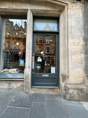 Single glass door with dark grey frame. Push from right to open.