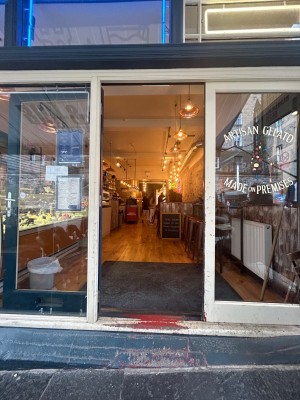 Single glass door with blue frame. Push from right to open.