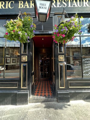 From pavement looking straight at black and gold double doors. Push from centre to open.