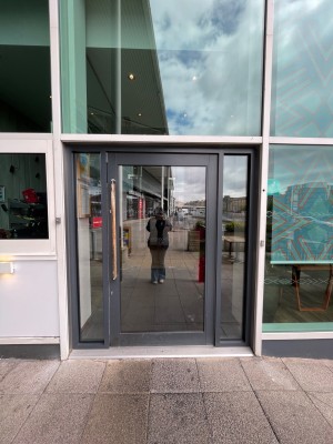 Black glass door with handle at right, push to open.