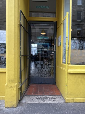 Slight bump when approaching door, then single door opens inwards from right to left.