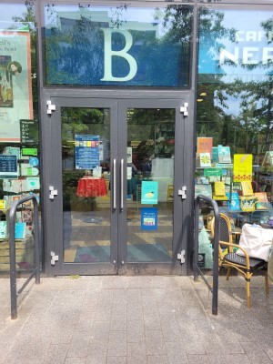 Glass doors ahead. Pull from metal handles in centre to open.