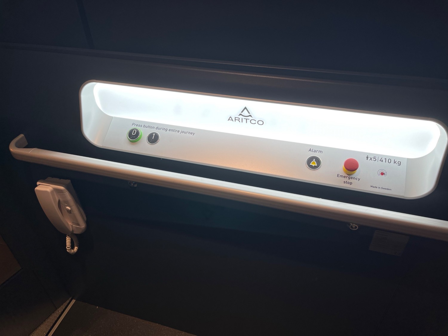 The control buttons for the lift. A handrail and emergency phone are below this panel.