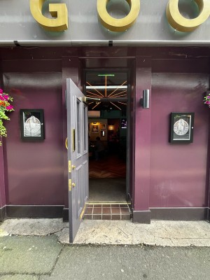 One step to grey door with glass panels ahead. Pull from golden handle on right to open.
