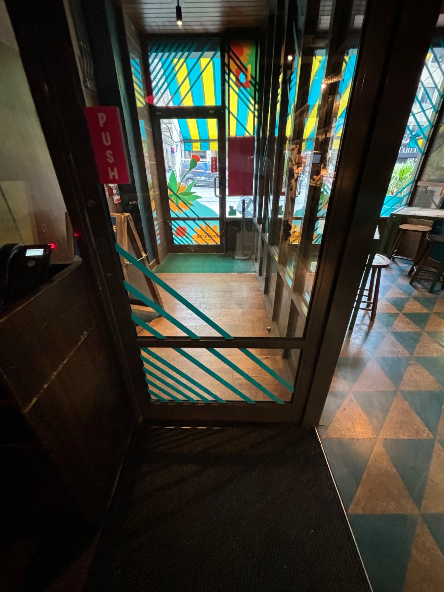 Exit metal glass door.
Metal bar on the left side of the door.
Carpet area with the bump to the first exit door and second exit door.