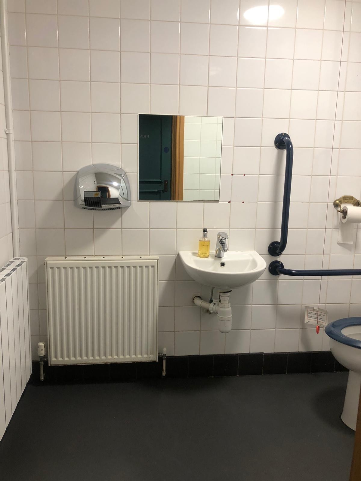 From door facing straight. Sink at back right.  Pull cord to its right.