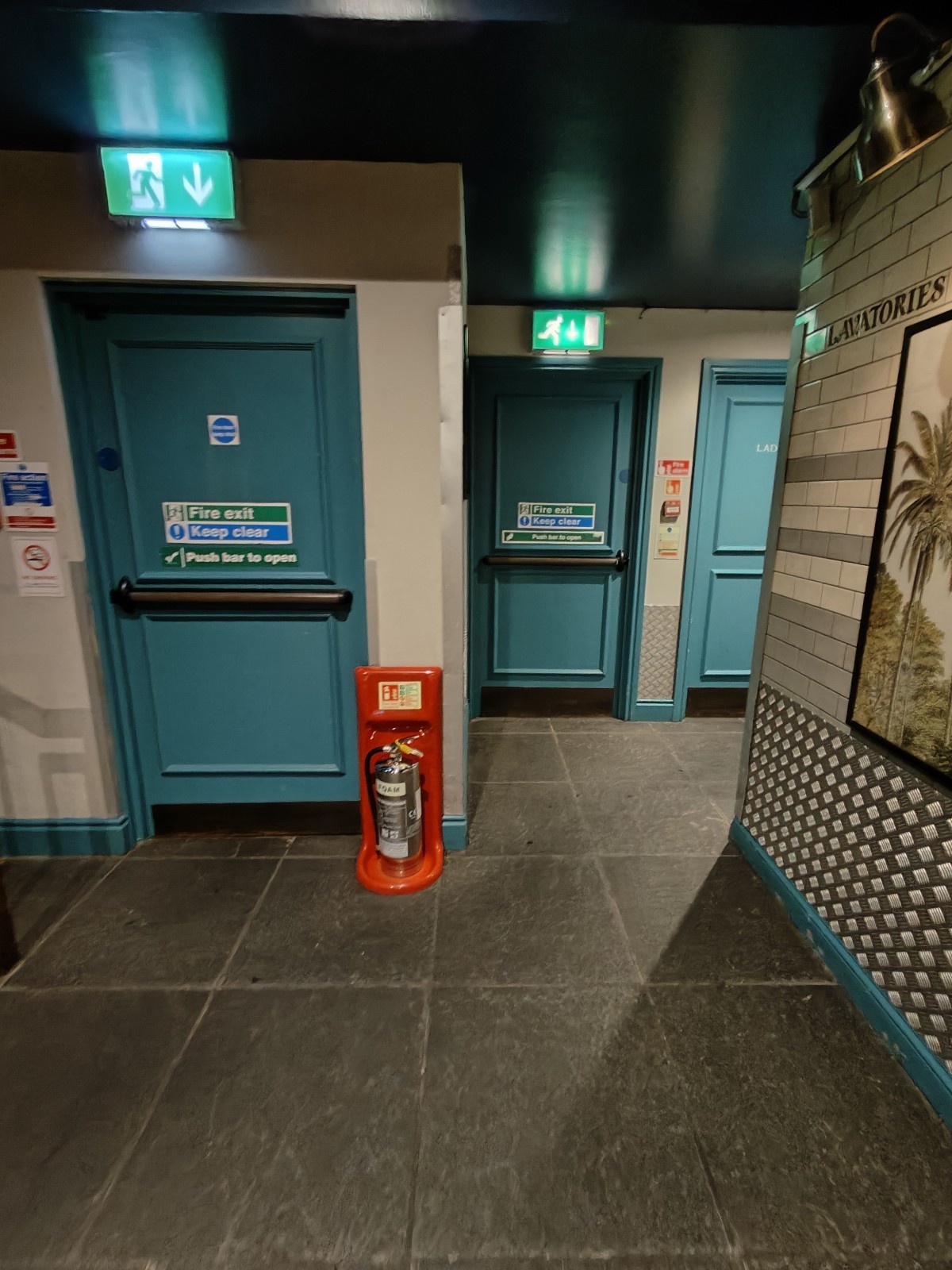 From outside lift facing left. Path ahead going right to toilet. Fire extinguisher ahead.