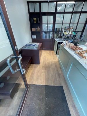 From entrance, looking straight. Counter along right, bench along left. Pathway straight down.