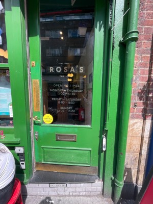 Green door with handle panel, handle at left. Push to open.