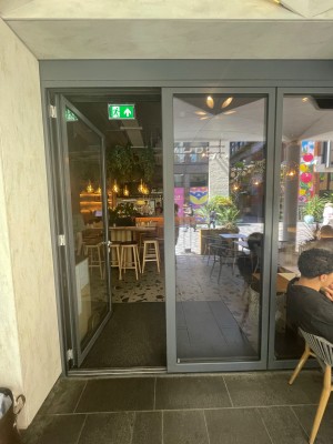 Black glass double doors with handle in centre, push to open.