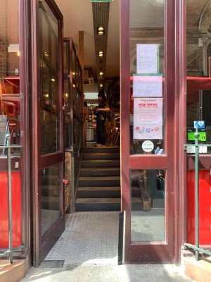 Double glass doors with brown wooden frames. Push from center to open.