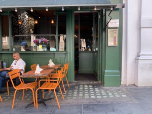 From street, facing entrance. Path straight to entrance door ahead. Outdoor seating to left of path.