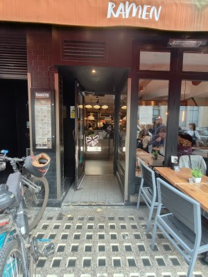 Black and glass panelled door with gold handle to right of door. Pull to open.