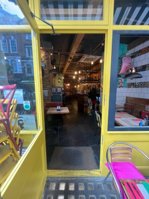 Yellow framed glass door. Pull open via handle on right.