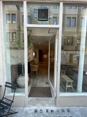 Glass door with handle at left, push to open.