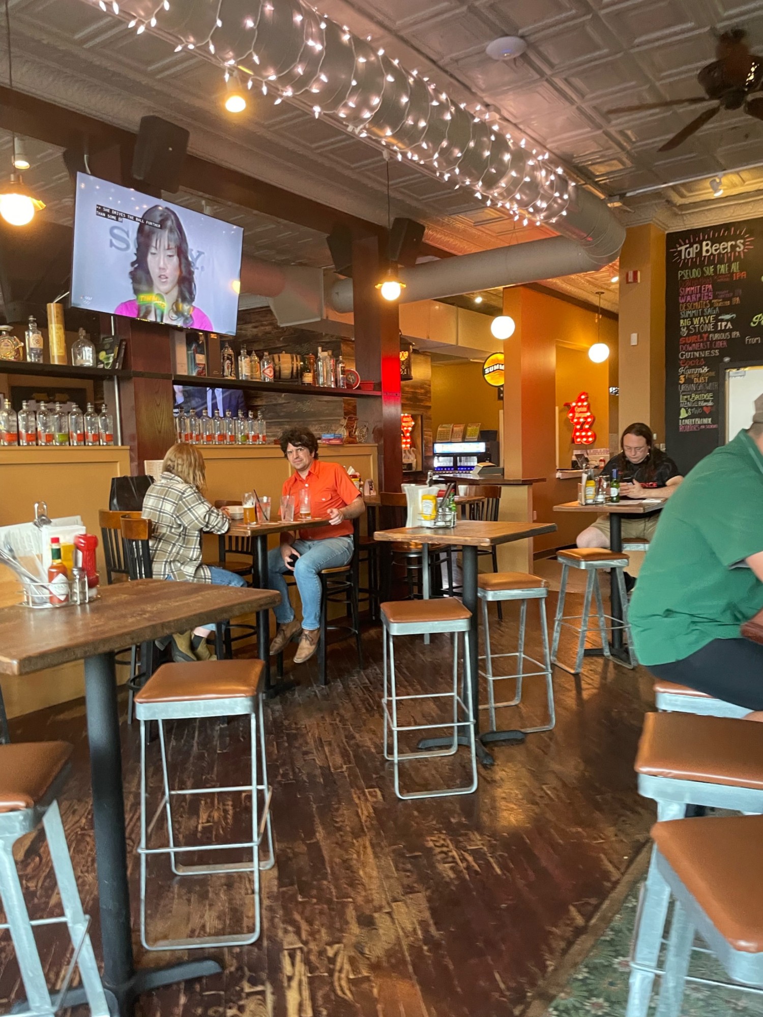 Hight tables to the right of the entrance and the bar with high seats
