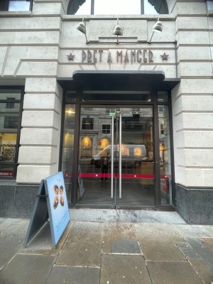Glass doors with dark brown metal frame. Silver vertical metal handles in centre. Pull to open.