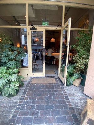 Glass double door, with yellow doorframe. Handles at centre. Pull to open.