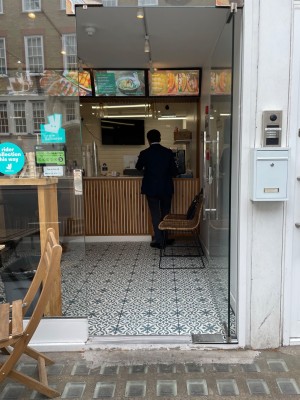 Single glass door with silver metal handle on left. Push to open.