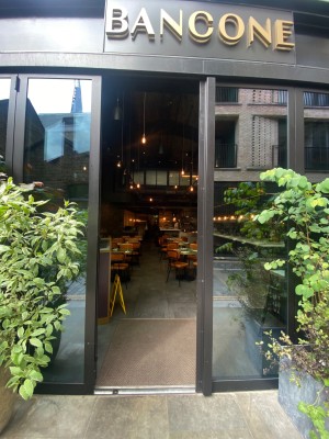 Glass door, with black doorframe. Vertical handle along right. Push to open.