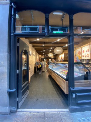 Glass door, with black wooden doorframe. Push on right of door to open.