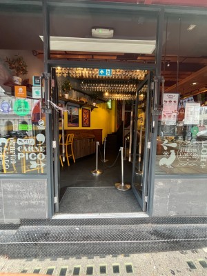 Double glass doors in grey metal frames. Push brown wooden handles from centre to open.