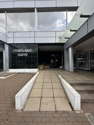 From pavement looking straight. Built-in ramp leading up to entrance ahead.